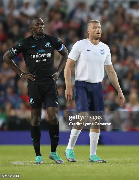 Usain Bolt of the Rest of the World and Andrew Flintoff of England look on during the Soccer Aid for UNICEF 2018 match between Englannd and the Rest...