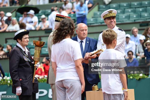 President of the French Tennis Federation Bernard Giudicelli supervises the arrival of the flame lit from the eternal flame at the tomb of the...