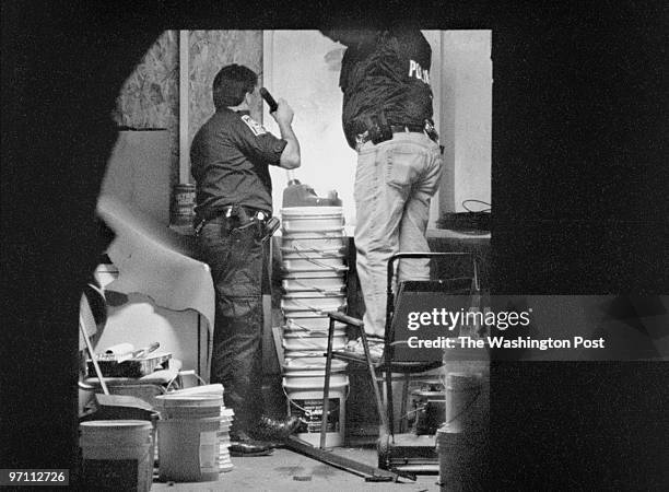 -- Prince William County police officers search an out building at the site of a drug bust that occurred on Maplewood Drive. Evidence was recovered...