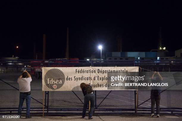 French National federation of Agricultural Holders' Unions and Young Farmers union members install a banner on a fence as they block the access of...