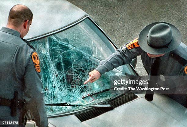 Virginia State Troopers check the windshield of a vehicle suspected to have been involved in a fatal auto-pedestrian accident. The car is on I-395...