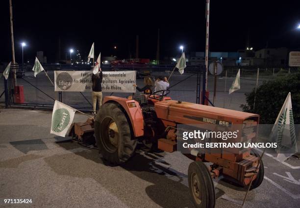 French National federation of Agricultural Holders' Unions and Young Farmers union members install flags on a fence as they block the access of...
