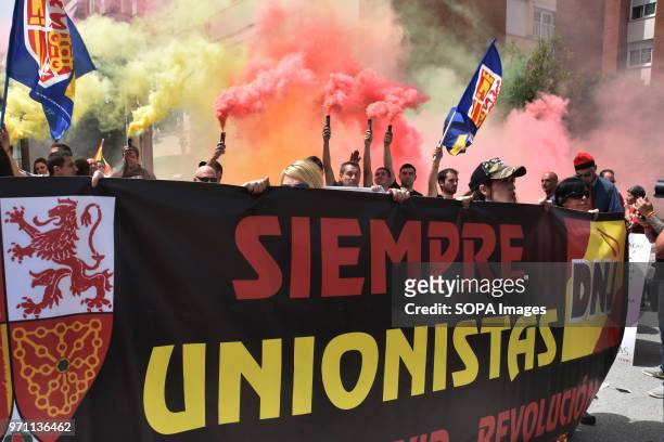Group of protesters with a huge banner and colored flares during the demonstration. Hundreds of people, fans and groups of the ultra right like...