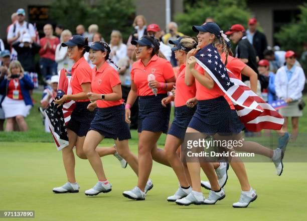 The United States team race onto the 18th green to celebrate after their 17-3 victory over the Gtreat Britain and Ireland team during the final day...