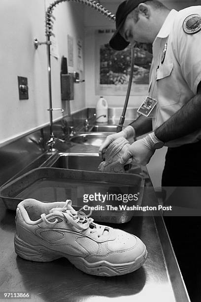 Passangers at the International Arrivals Terminal at Dulles Airport. This is Tony Roman Senrio PPQ Officer cleaning some shoes that have been taken...
