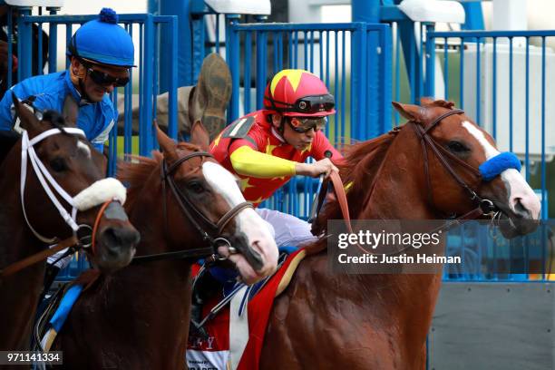 Justify, ridden by jockey Mike Smith and Free Drop Billy, ridden by jockey Robby Albarado breaks from the gate during the 150th running of the...