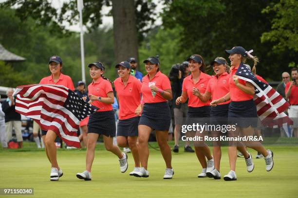The United States team runs onto the 18th green after defeating the Great Britain and Ireland team 17-3 on day three of the 2018 Curtis Cup Match at...