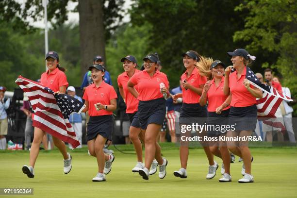 The United States team runs onto the 18th green after defeating the Great Britain and Ireland team 17-3 on day three of the 2018 Curtis Cup Match at...