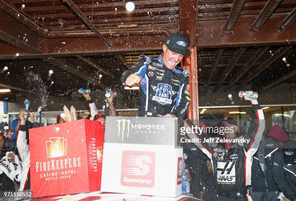 Clint Bowyer, driver of the Haas 30 Years of the VF1 Ford, celebrates after winning the Monster Energy NASCAR Cup Series FireKeepers Casino 400 at...