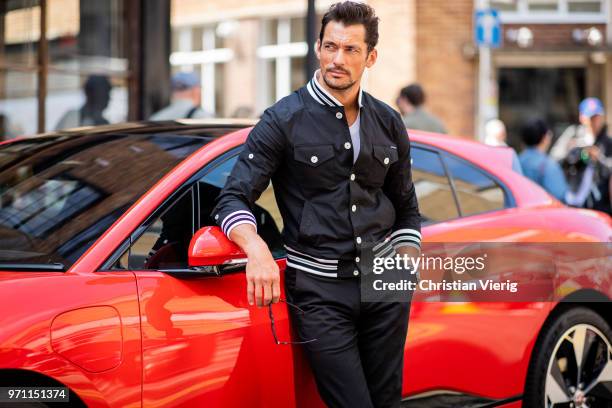 David Gandy wearing college jacket in front of a Jaguar is seen during London Fashion Week Men's June 2018 on June 10, 2018 in London, England.