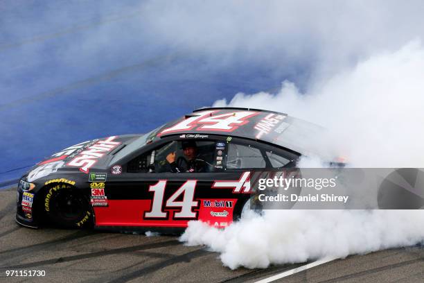 Clint Bowyer, driver of the Haas 30 Years of the VF1 Ford, celebrates with a burnout after winning the Monster Energy NASCAR Cup Series FireKeepers...