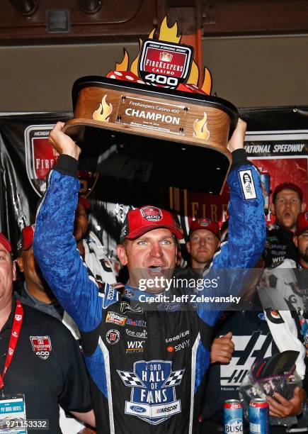 Clint Bowyer, driver of the Haas 30 Years of the VF1 Ford, celebrates with the trophy after winning the Monster Energy NASCAR Cup Series FireKeepers...