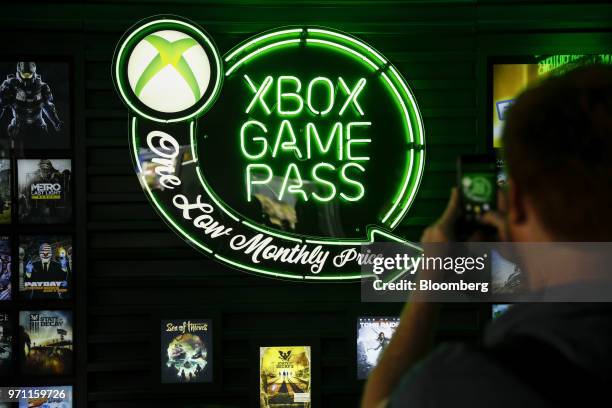 An attendee takes a photograph of Xbox Game Pass signage following the Microsoft Corp. Xbox event ahead of the E3 Electronic Entertainment Expo in...