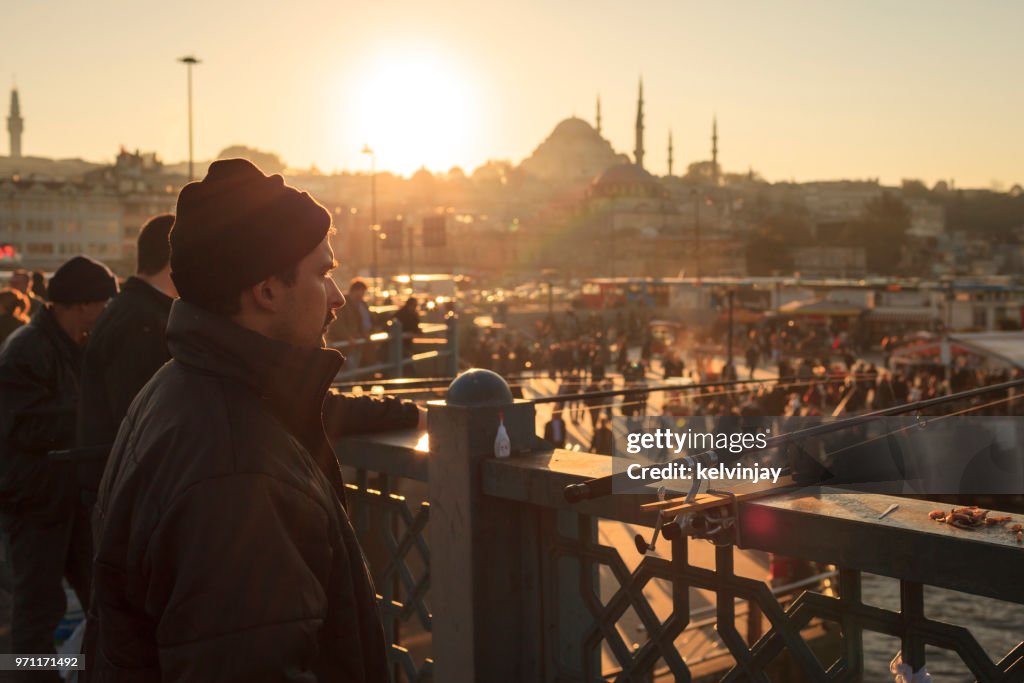 Männer Angeln bei Sonnenuntergang auf der Galata-Brücke, Istanbul, Türkei