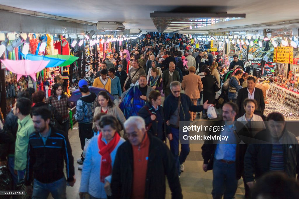 Pedestrians walking past shops in a busy underpass in Istanbul, Turkey