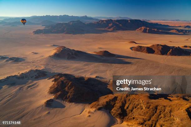 aerial view from a balloon of another balloon cruising over the sossusvlei area at dawn, namib desert, namib-naukluft, namibia (property release) - namib desert stock-fotos und bilder