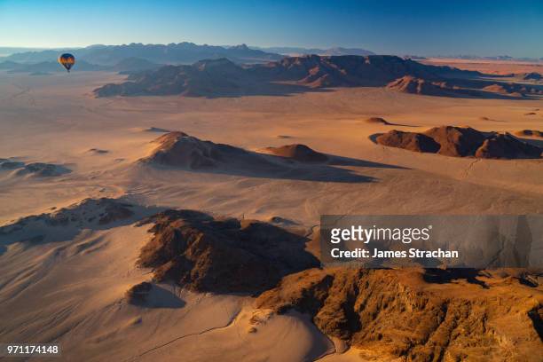 aerial view from a balloon of another balloon cruising over the sossusvlei area at dawn, namib desert, namib-naukluft, namibia (property release) - africa abstract stockfoto's en -beelden