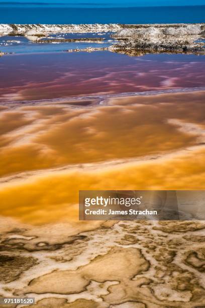extraordinarily vibrant layers of colour created by the chemicals in the salt pans, walvis bay, namibia - james strachan stock pictures, royalty-free photos & images