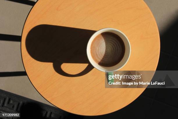 top view of coffee cup on cafe table with big shadow - chocolate swirl from above stock pictures, royalty-free photos & images