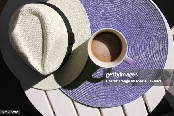 top view of coffee cup with straw hat on purple placemat - marie lafauci stock pictures, royalty-free photos & images