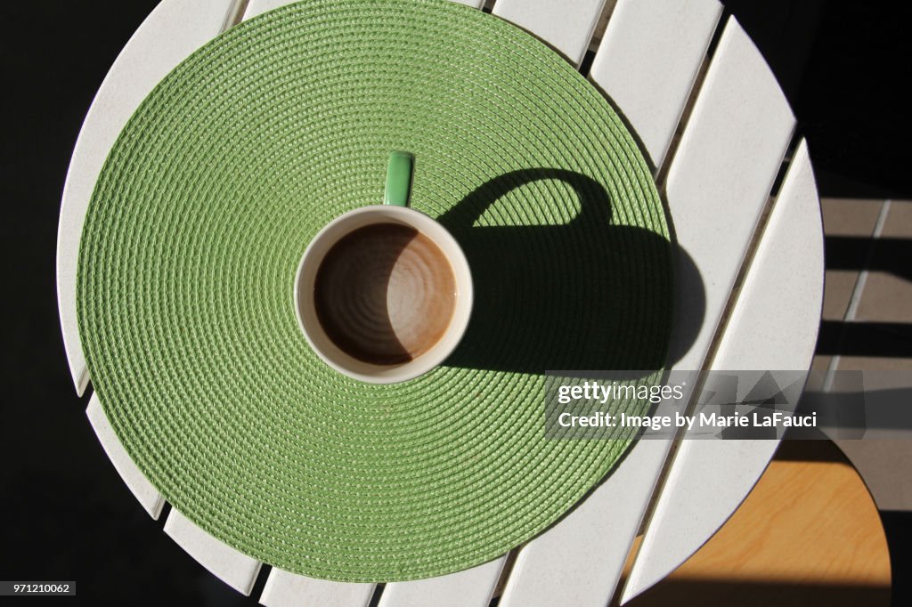Top view of coffee cup on green placemat