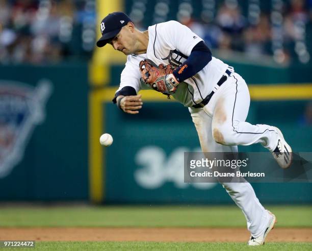 Shortstop Jose Iglesias of the Detroit Tigers throws wide of first base after fielding a grounder hit by Ian Kinsler of the Los Angeles Angels during...