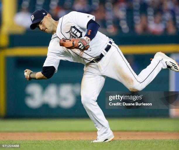 Shortstop Jose Iglesias of the Detroit Tigers throws wide of first base after fielding a grounder hit by Ian Kinsler of the Los Angeles Angels during...