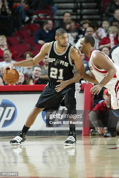 Tim Duncan of the San Antonio Spurs drives the ball past Chuck Hayes of the Houston Rockets on February 26, 2010 at the Toyota Center in Houston,...