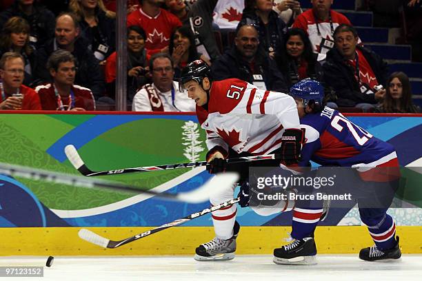 Ryan Getzlaf of Canada battles for the puck with Richard Zednik of Slovakia during the ice hockey men's semifinal game between the Canada and...