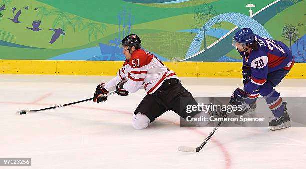 Ryan Getzlaf of Canada reaches for the puck next to Richard Zednik of Slovakia during the ice hockey men's semifinal game between the Canada and...