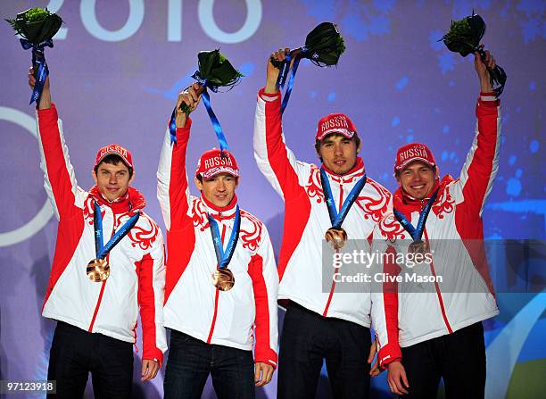 Ivan Tcherezov, Maxim Tchoudov, Anton Shipulin and Evgeny Ustyugov of Russia celebrate winning the bronze medal during during the medal ceremony for...