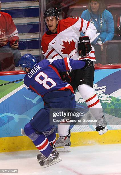 Martin Cibak of Slovakia is checked onto the boards by Ryan Getzlaf of Canada during the ice hockey men's semifinal game between the Canada and...