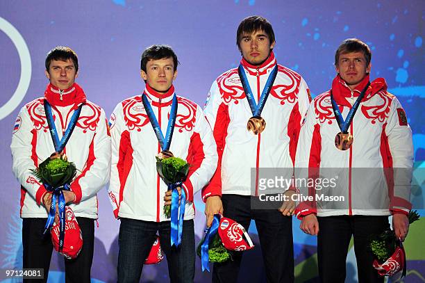 Ivan Tcherezov, Maxim Tchoudov, Anton Shipulin and Evgeny Ustyugov of Russia celebrate winning the bronze medal during during the medal ceremony for...