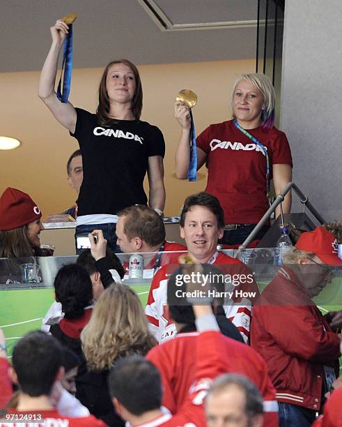 Heather Moyse and Kaillie Humphries shows their gold medals as they attend the ice hockey men's semifinal game between the Canada and Slovakia on day...