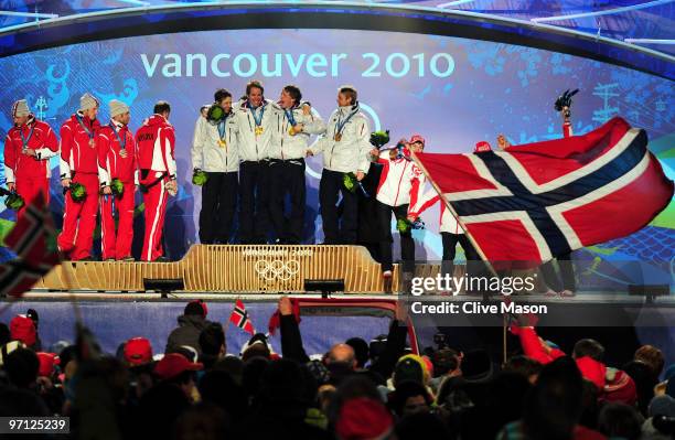 Team Austria celebrates winning the silver medal, team Norway gold and team Russia bronze during the medal ceremony for the men�s 4 x 7.5 biathlon...