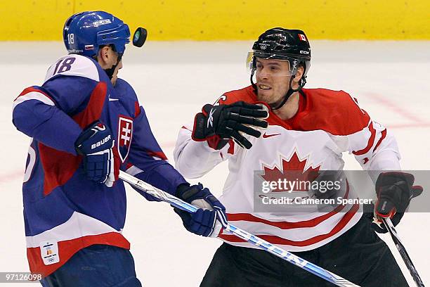 Shea Weber of Canada looks at the puck next to Miroslav Satan of Slovakia during the ice hockey men's semifinal game between the Canada and Slovakia...