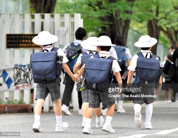 School pupils arrive at the school on the 17th anniversary of the stabbing rampage at the Osaka Kyoiku University Ikeda Elementary School on June 8,...