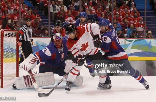 Jarome Iginla of Canada battles for the puck with Lubomir Visnovsky of Slovakia during the ice hockey men's semifinal game between the Canada and...
