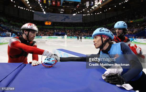 Disqualified Apolo Anton Ohno of the United States shakes hands with bronze medalist Francois-Louis Tremblay of Canada as he leaves the ice in the...