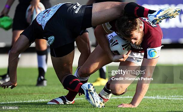 David Williams of the Sea Eagles ducks underneath the tackle of Joel Moon of the Warriors during the NRL trial match between the Warriors and the...