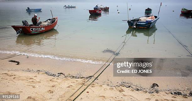 Fisherman prepares his boat in thick fog near Stanley, Hong Kong on February 27, 2010. As heavy snow blizzards are affecting parts of mainland China,...