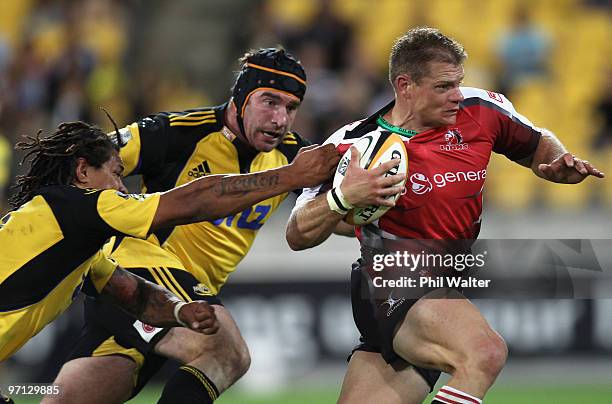 Deon van Rensburg of the Lions is tackled by Rodney So'oialo and Andrew Hore of the Hurricanes during the round three Super 14 match between the...