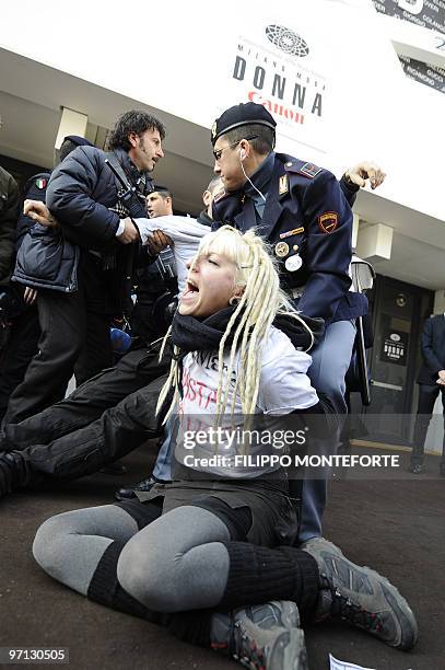 Police try to remove anti-fur activists wearing tee-shirts reading "enough fur" demonstrating against Max Mara outside the entrance of Milano Fiera...