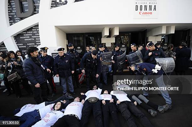 Police try to remove anti-fur activists wearing tee-shirts reading "enough fur" demonstrating against Max Mara outside the entrance of Milano Fiera...