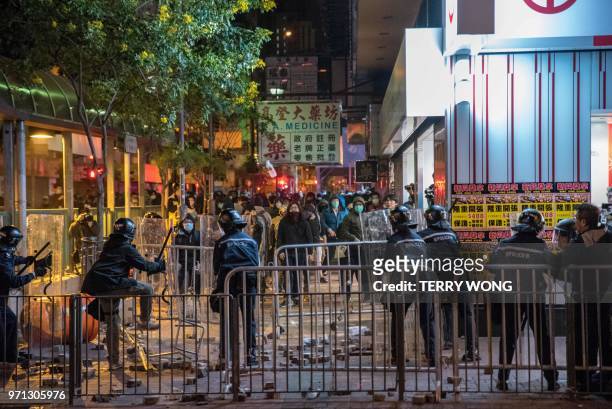 In this photo taken on February 9 protesters throw objects at police during clashes, later dubbed the "Fishball Revolution", in the Mongkok area of...