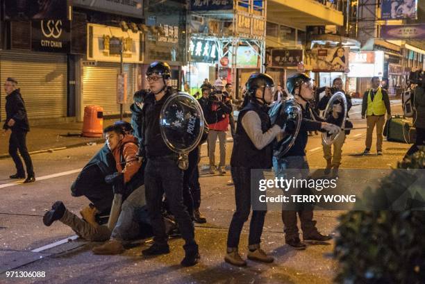 In this photo taken on February 9 police stand guard during clashes with protesters, later dubbed the "Fishball Revolution", in the Mongkok area of...