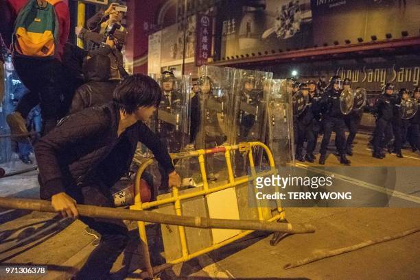 In this photo taken on February 9 a protester holds a piece of bamboo and a barricade during clashes with police, later dubbed the "Fishball...