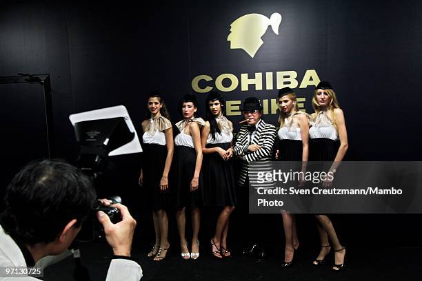 Guest poses for a photo with Cuban models at an auction of humidors and gala dinner smoke Cuban cigars at the end of the annual five day Habanos...