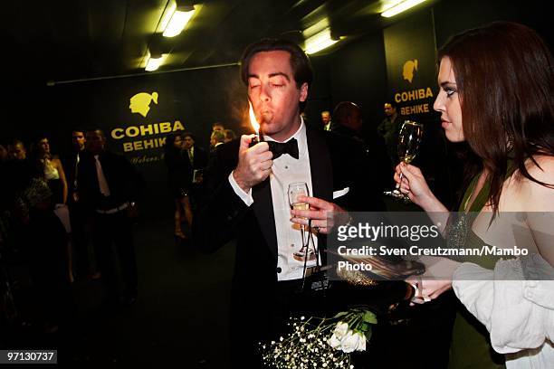 Man lights up his Cuban cigar during an auction of humidors and gala dinner smoke Cuban cigars at the end of the annual five day Habanos Tobacco...