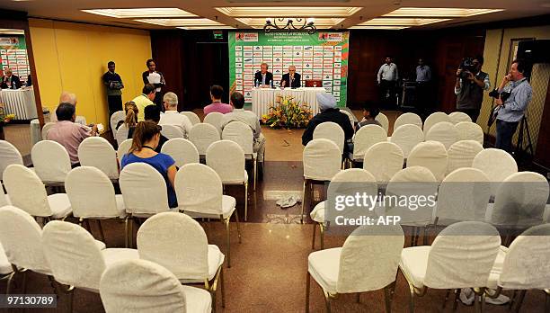 International Hockey Federation President Leandro Negre and FIH spokesman Arjen Meijer watch an almost empty press conference venue after journalists...